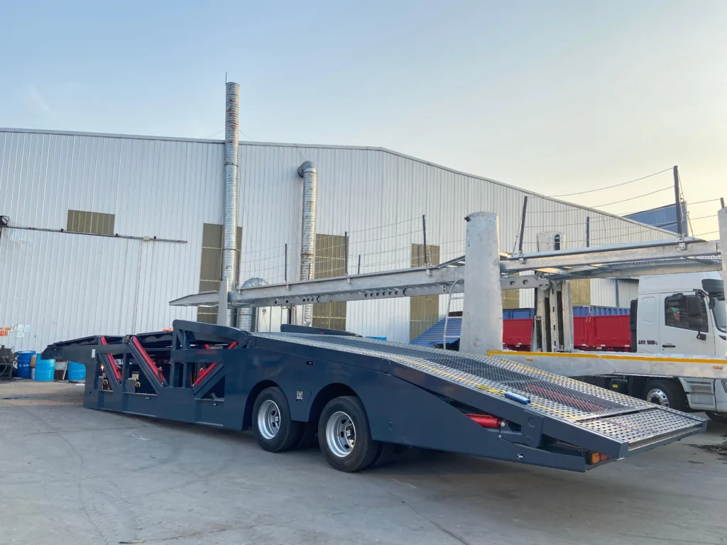 Grey two-axle car carrier semi-trailer with empty upper and lower decks