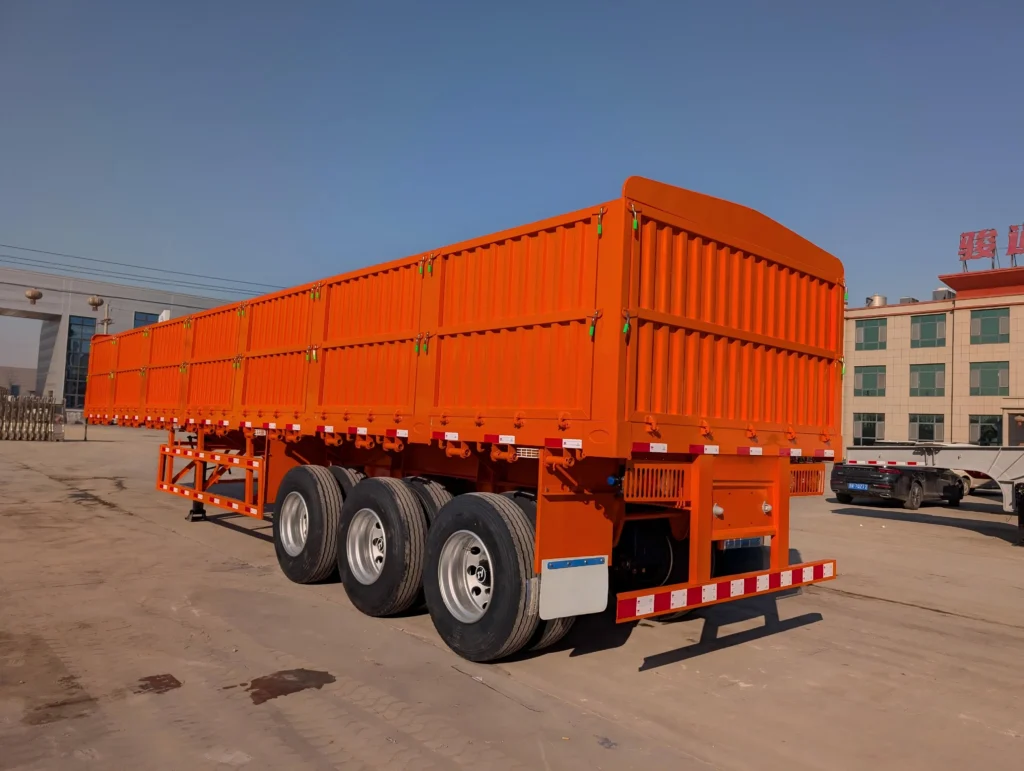Orange cargo semi-trailer with closed rear doors and three rear axles