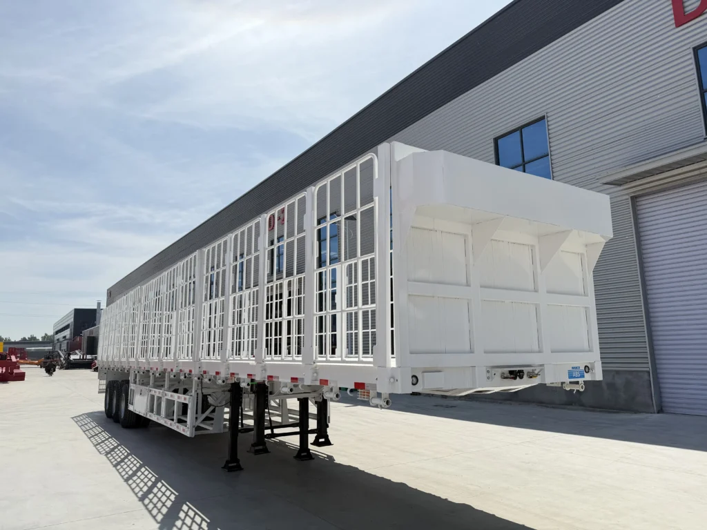 White three-axle fence cargo semi-trailer parked in the factory yard