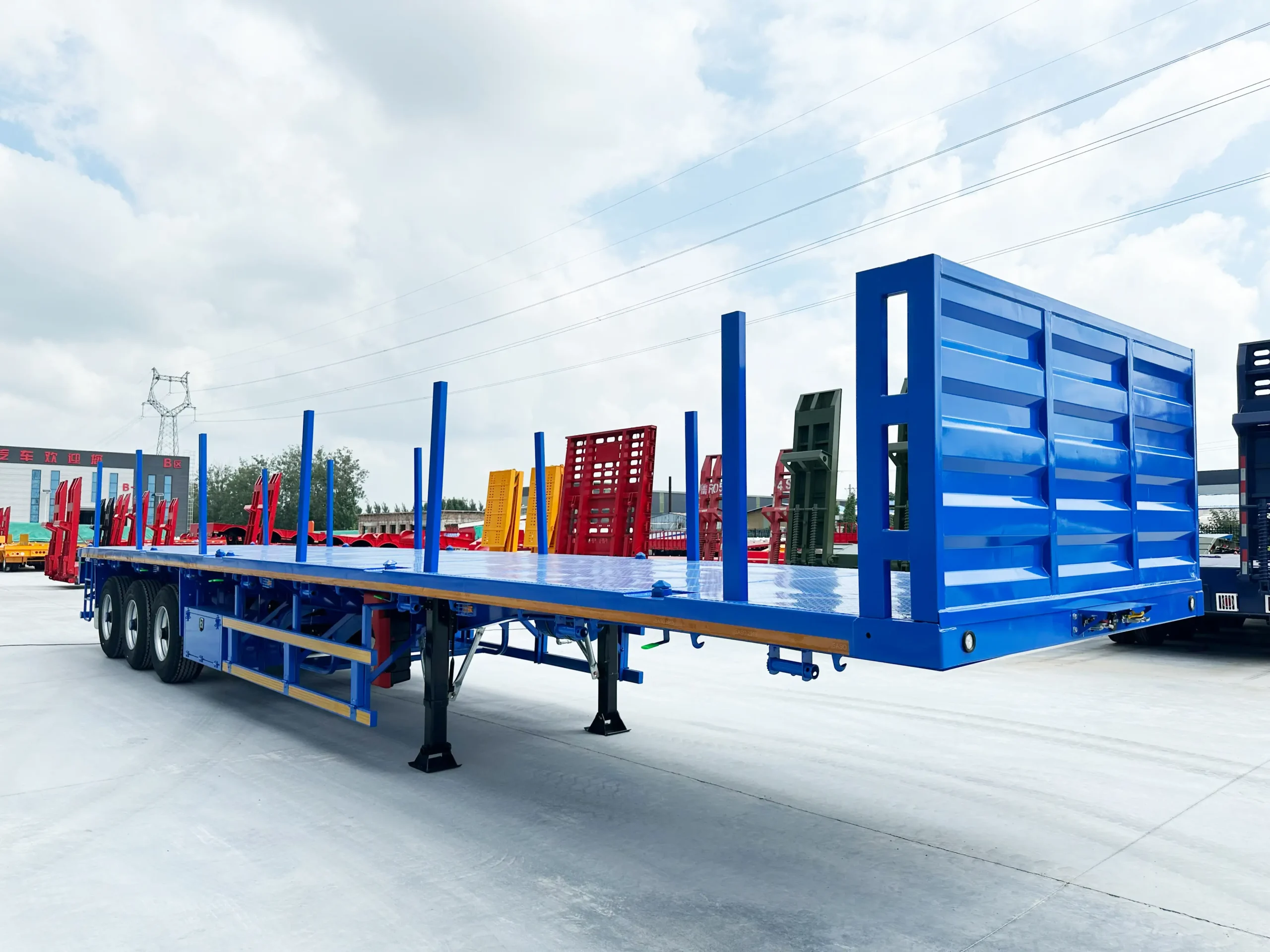 Front three-quarter view of a three-axle flatbed semi trailer