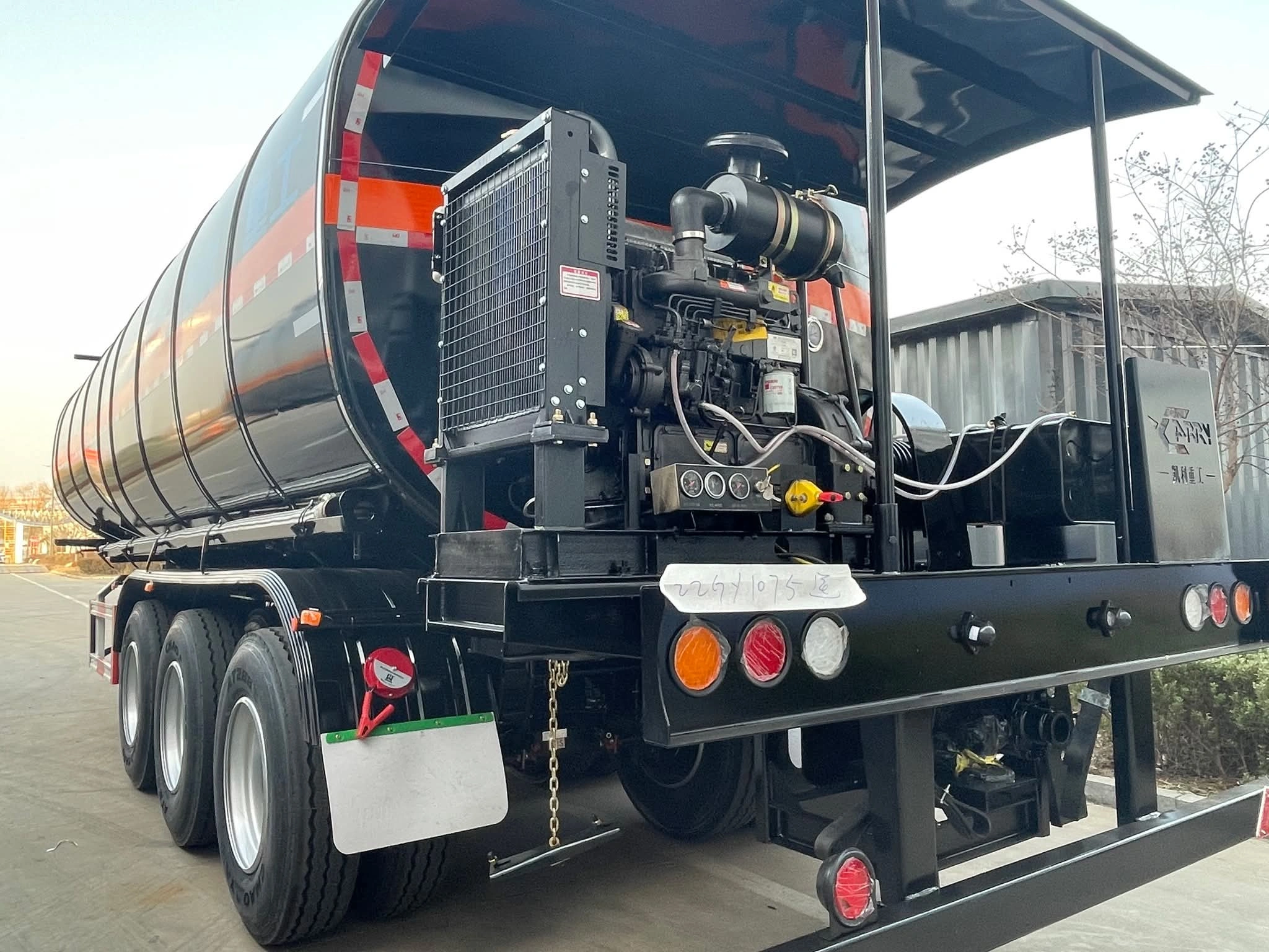 Heating and auxiliary equipment area on three-axle asphalt tanker trailer