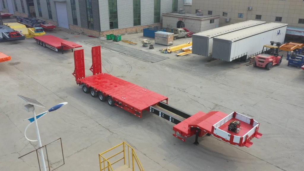 Red lowbed trailer viewed from above with its gooseneck extension exposed