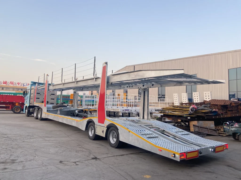 Galvanized double-deck car carrier with red panels on its upright supports