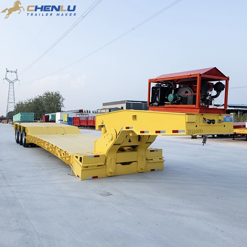 Front-quarter view of a yellow lowbed trailer with a raised gooseneck and power unit