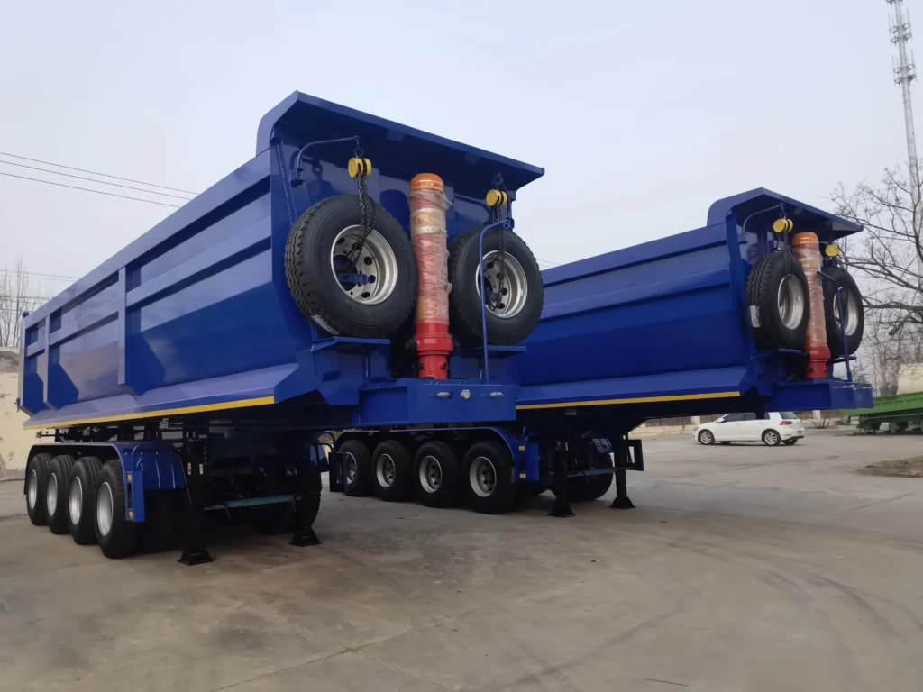 Blue four-axle dump semi-trailer with two front-mounted spare wheels