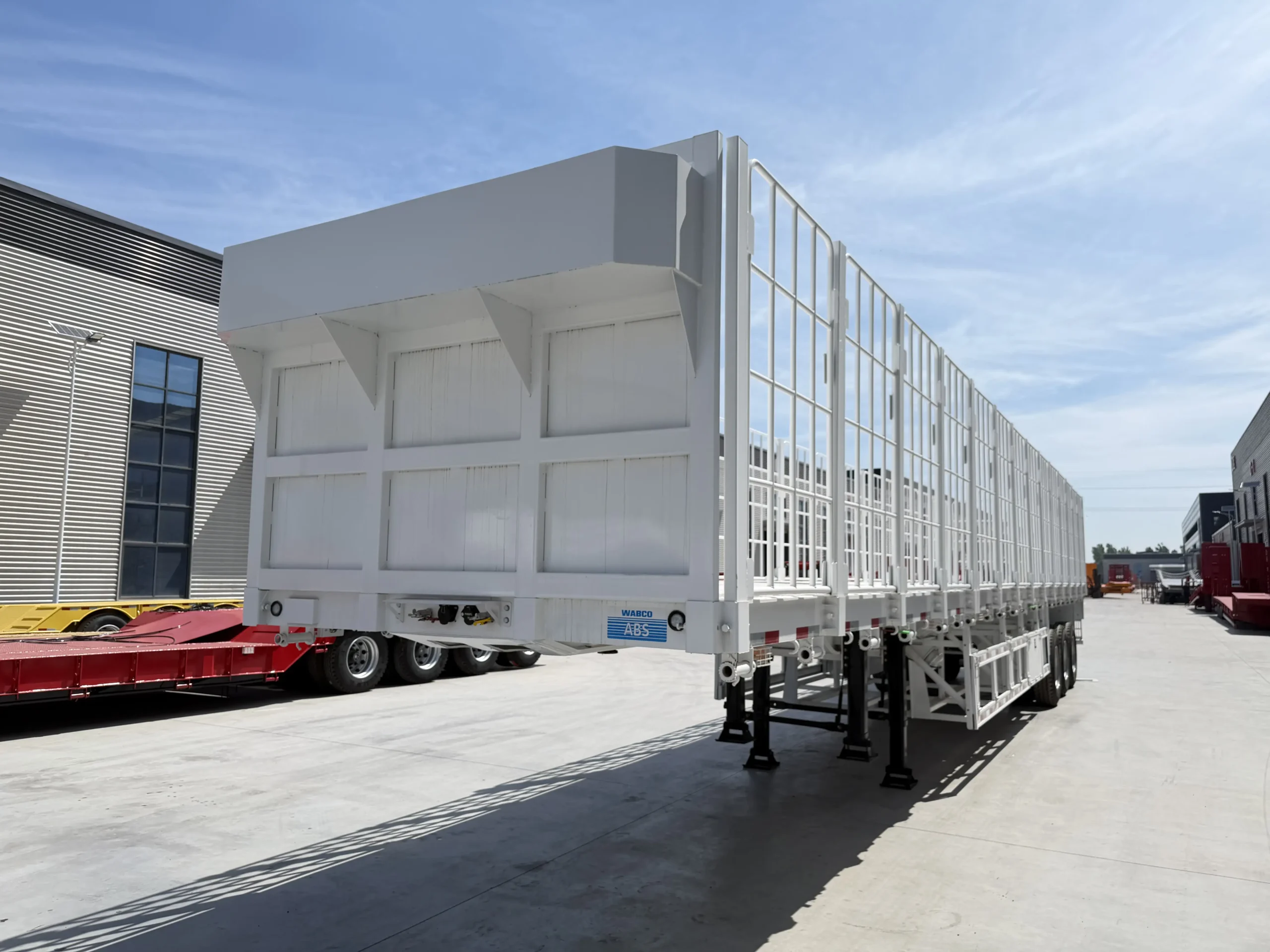 Rear three-quarter view of the three-axle fence cargo semi trailer