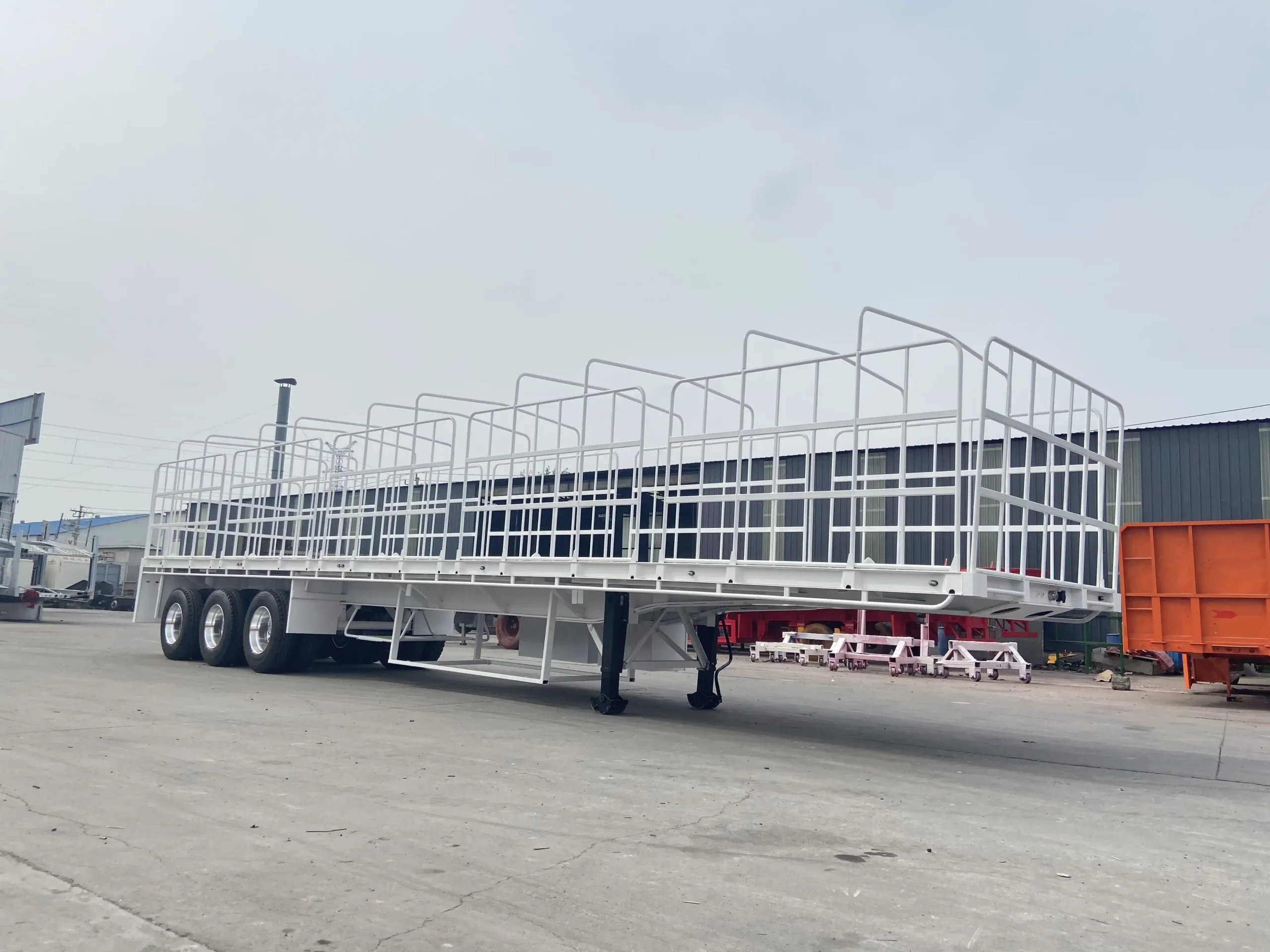 White tri axle flat top semi trailer with tubular side gates
