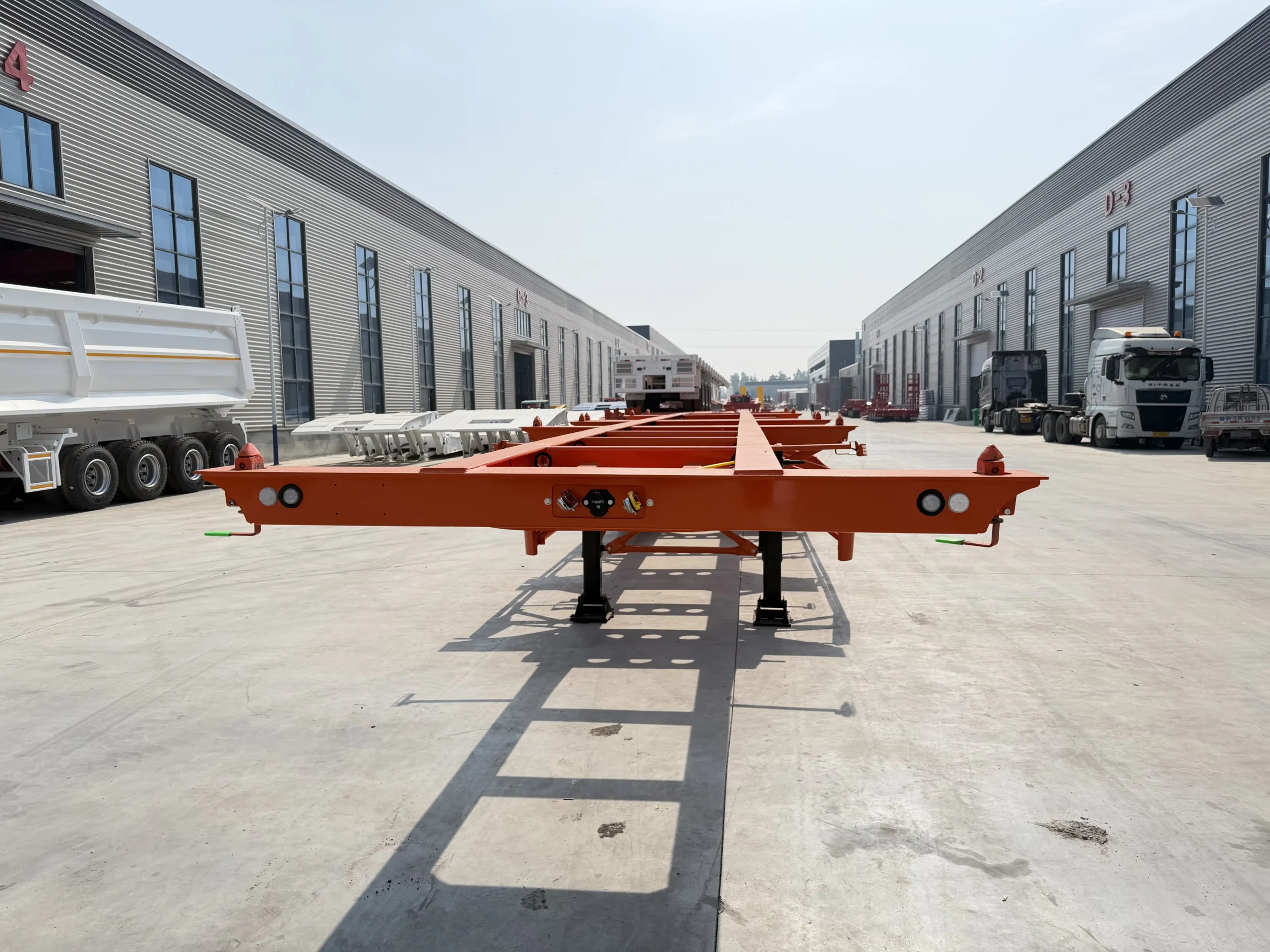 Front view of an orange CHENLU skeletal container chassis showing the front crossmember and container-lock fittings