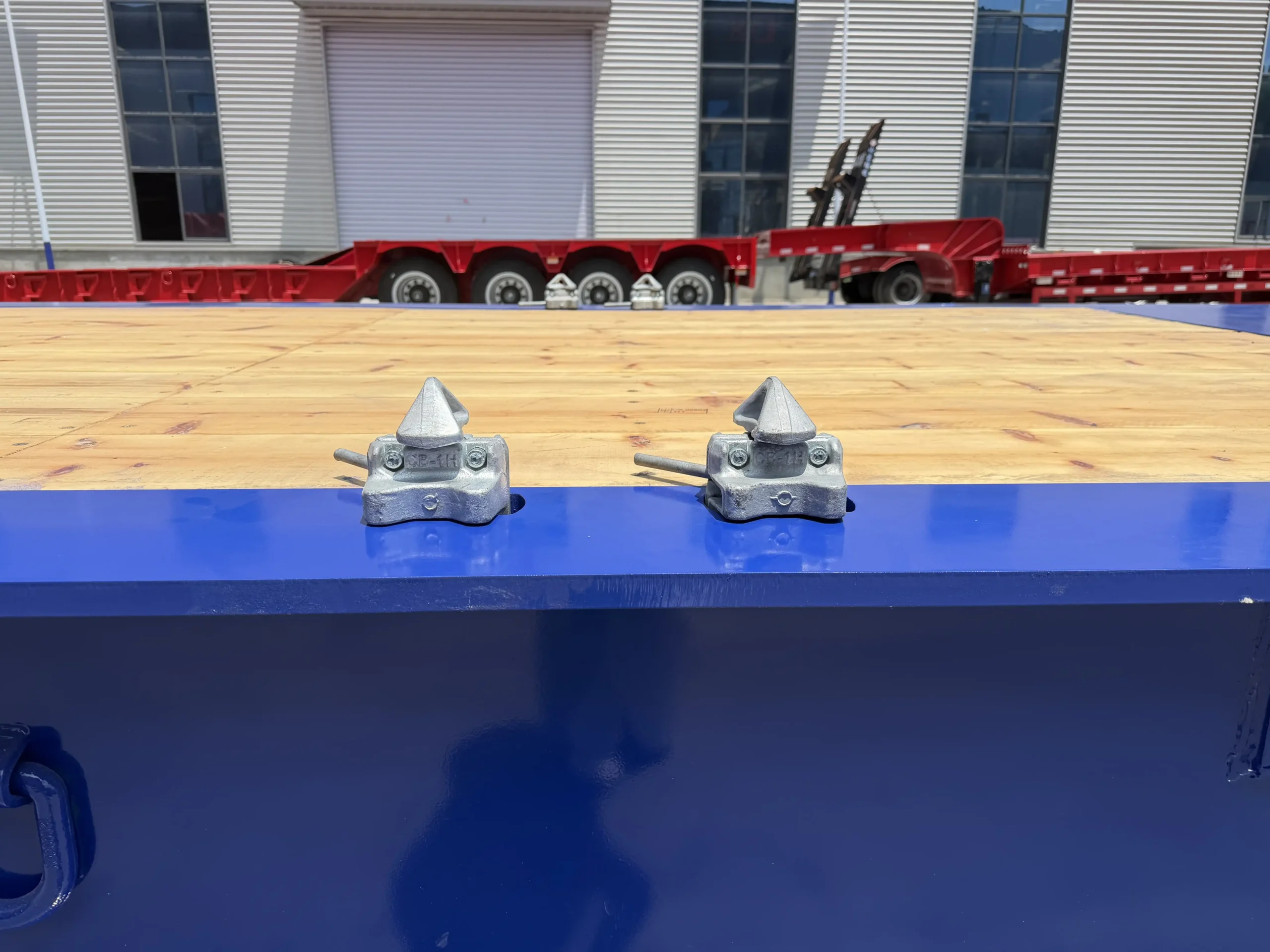 Side tie-down fittings on a two-axle folding gooseneck lowbed deck