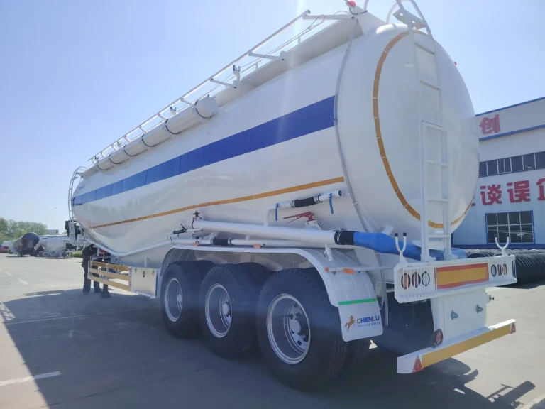 White three-axle bulk cement tanker with discharge pipework