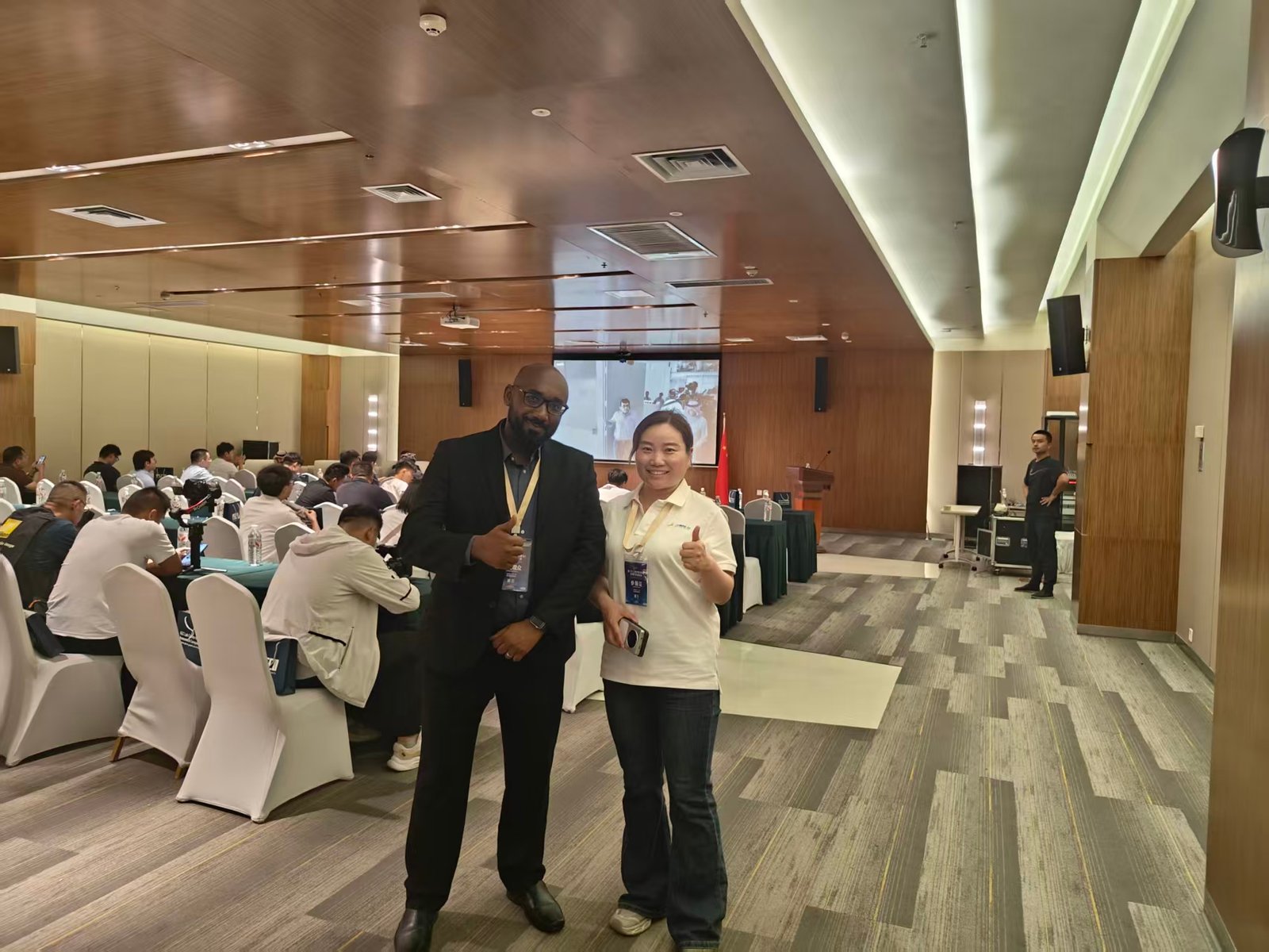 Two event participants photographed together in the conference hall
