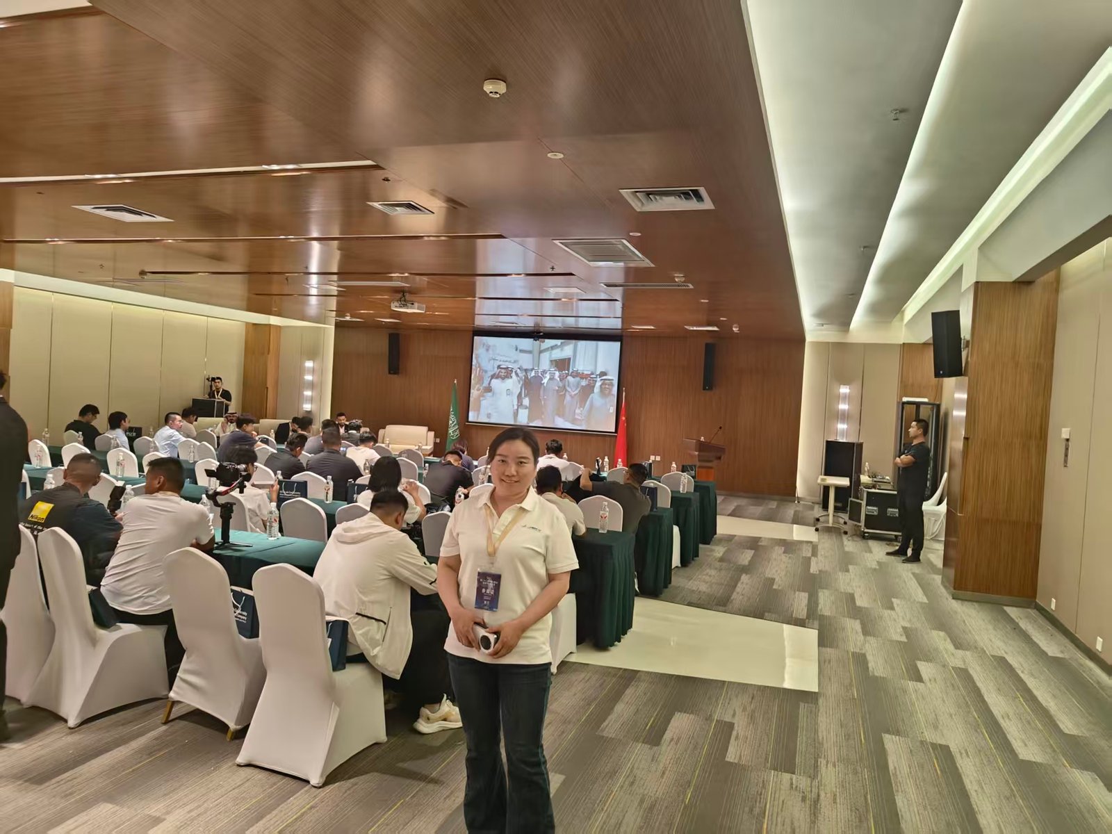 An attendee standing beside the seating area in the conference hall