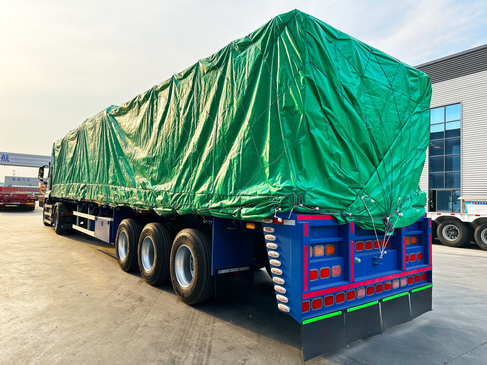Rear view of the three-axle flatbed trailer and tarpaulin-covered load for Chile
