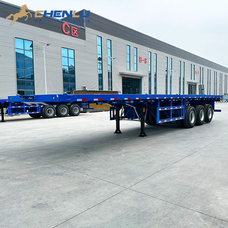 Side view of the clear open deck on the blue three-axle flatbed semi-trailer