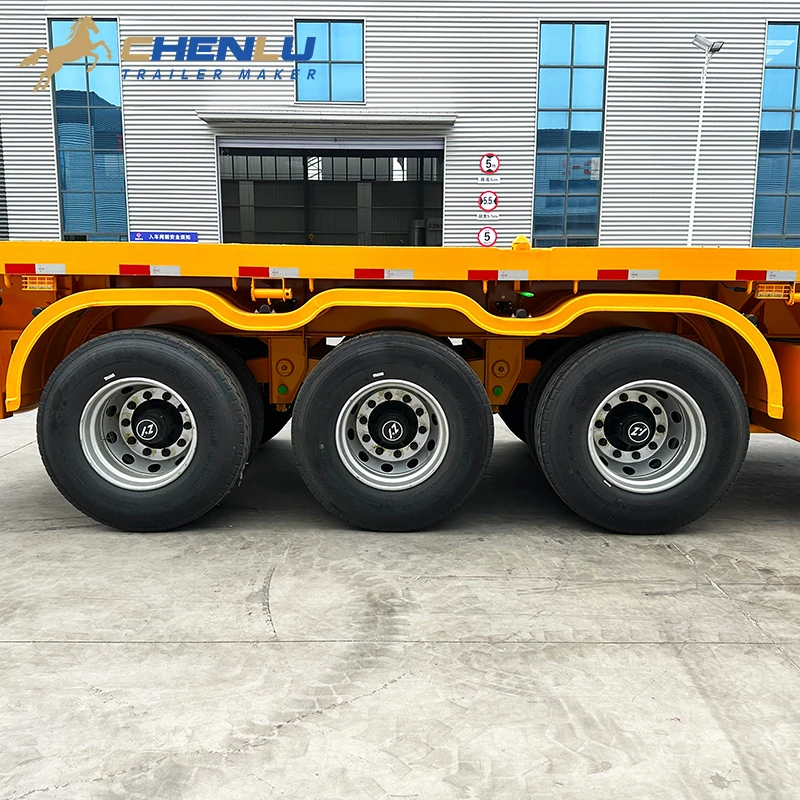Three-axle wheel group on the yellow 60 ton flatbed semi trailer